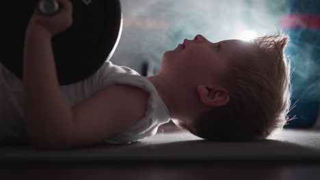 Cute-little-boy-takes-break-before-lifting-heavy-barbell