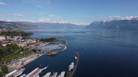 downward aerial tilt above a dock in lausanne, switzerland along the lake geneva waterfront on a sunny day