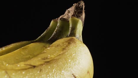 three banana bunch rotating on black. slow motion, 60 fps