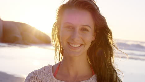 Portrait-of-beautiful-girl-smiling-on-beach-at-sunset-in-slow-motion