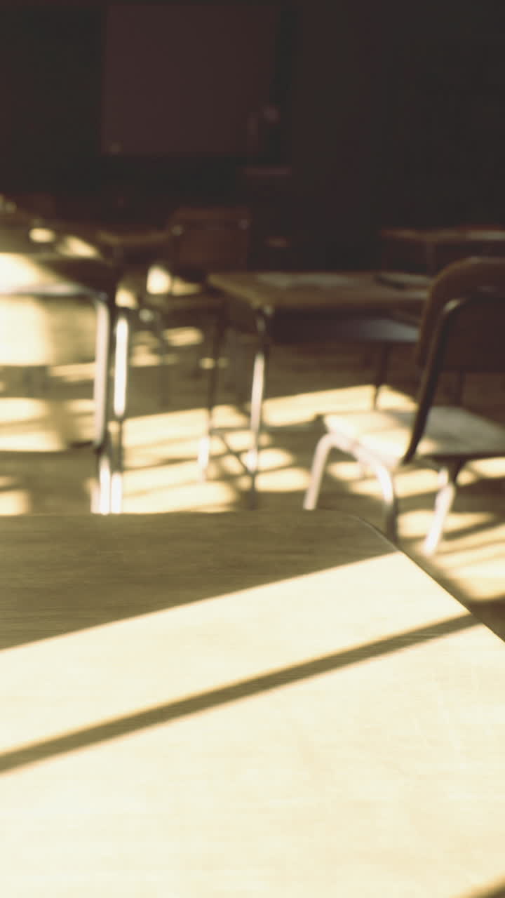 Sunlight shines through classroom windows and casts shadows on desks and chairs