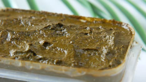 henna paste in container with palm leaves