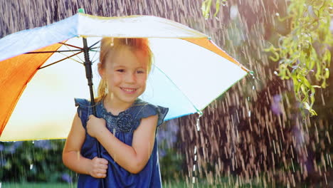 Sorgloses-Mädchen-Drei-Jahre-Unter-Dem-Regenschirm-Der-Farbe,-Die-Sich-Vor-Dem-Regen-Versteckt