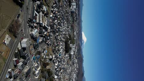 vertical drone flight over tokyo suburbs with mount fuji in distance