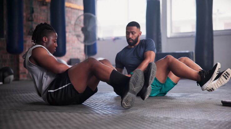 Men Doing Medicine Ball Crunches in a Gym