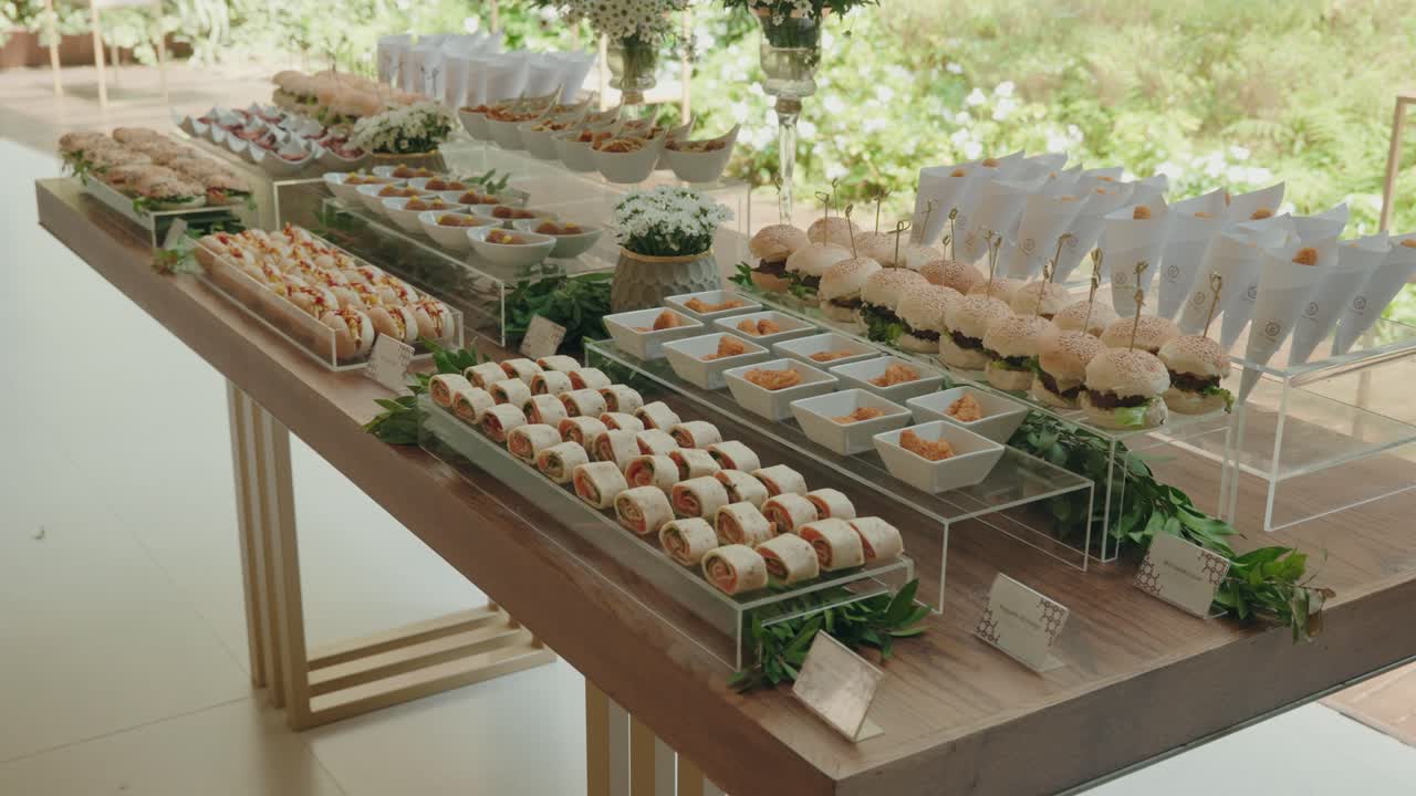 elegantly arranged wedding buffet table with mini burgers wraps and assorted gourmet appetizers