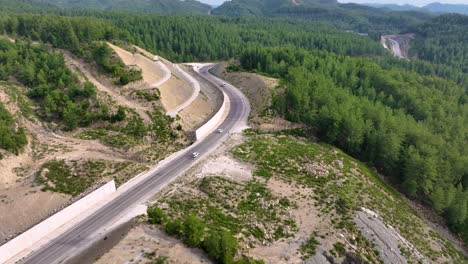 aerial view of winding mountain road through forest