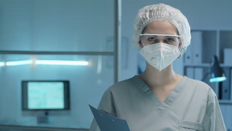 portrait of female lab worker in protective uniform