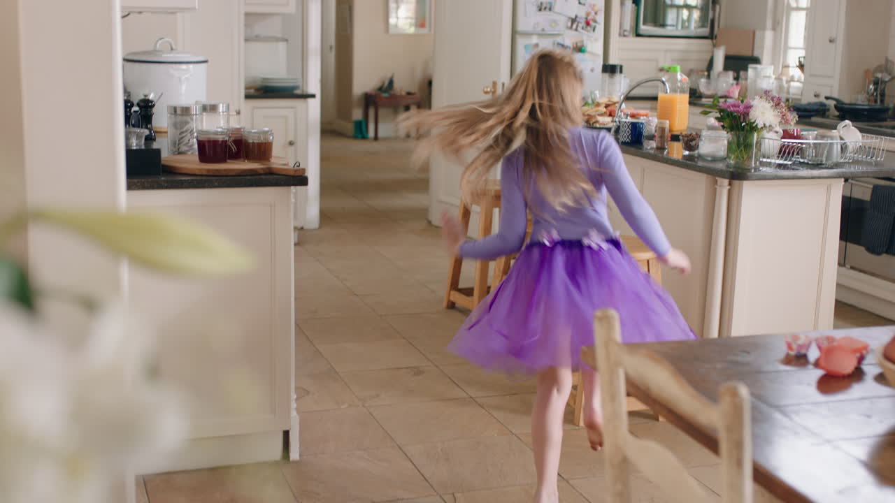 una bailarina feliz bailando en la cocina con un tutu púrpura divirtiéndose realizando movimientos de baile divertidos disfrutando de la celebración del fin de semana en casa