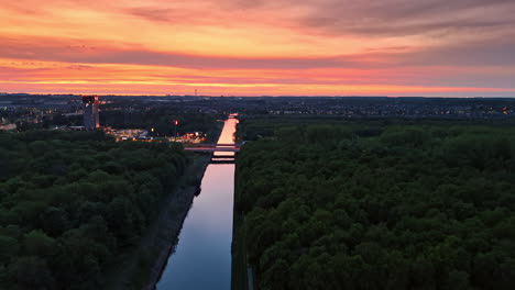 sunset over canal in netherlands. vibrant sunset casts colorful reflections on the calm canal surrounded by lush greenery in the netherlands