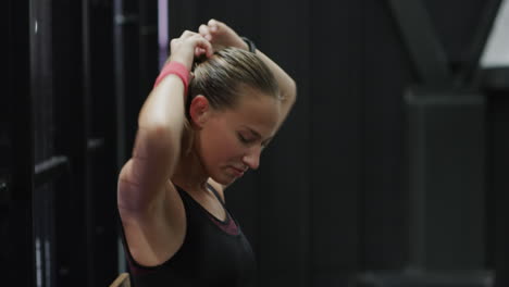 focused woman preparing for padel tennis match, wearing athletic gear on indoor court