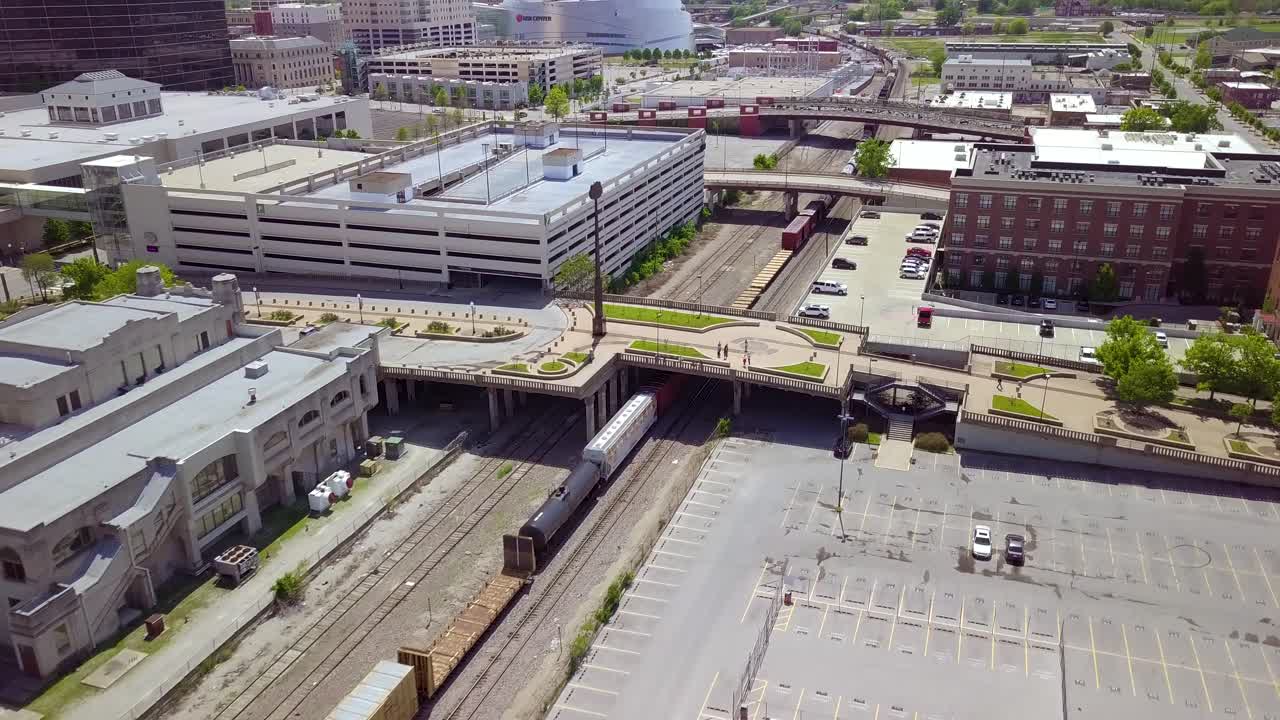 Aerial drone footage flying over railroad tracks alongside a train in downtown Tulsa