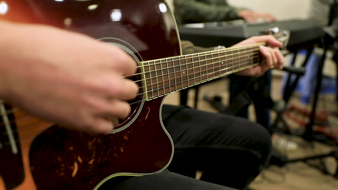 Male hands playing the guitar in the studio - slow motion
