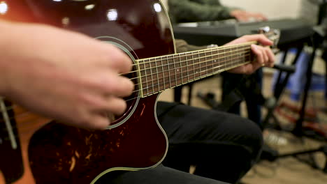 male hands playing the guitar in the studio - slow motion