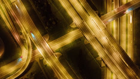 Timelapse-Aerial-view-of-a-freeway-intersection-at-night-with-cars-and-traffic