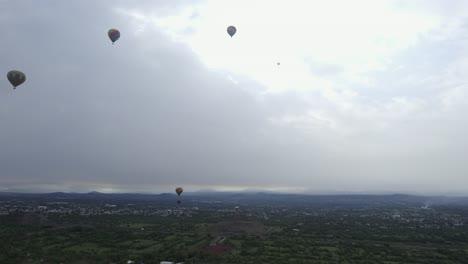 Globos-Aerostáticos-Volando-Sobre-Un-Sombrío-Campo-De-San-Juan,-México---Vista-Aérea