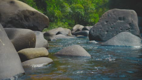 peaceful river flows over smooth rocks in khao sok national park, thailand