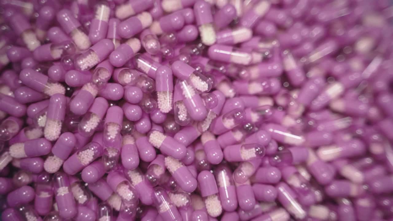 Bulk purple capsules falling down in a large pharmaceutical storage place.