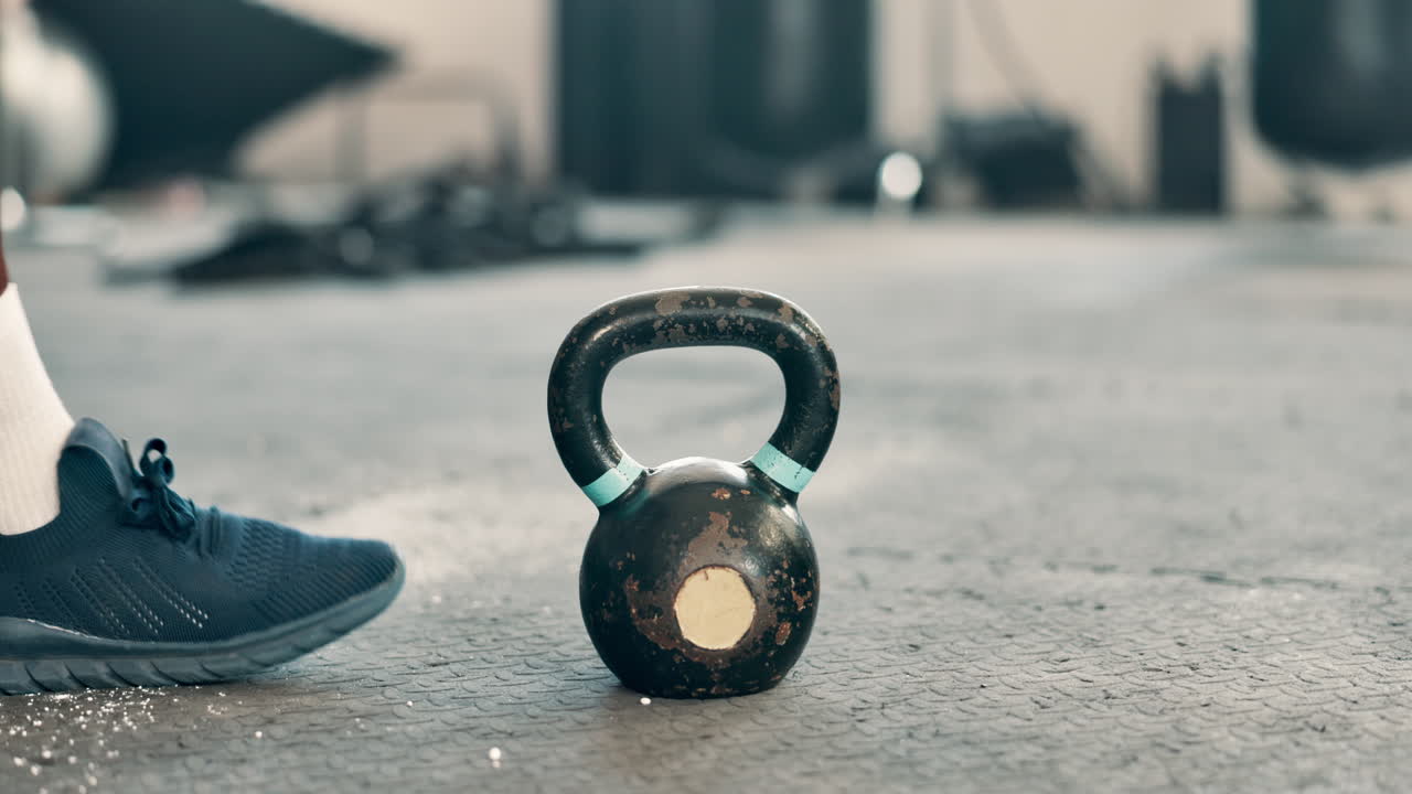 체육관 에서 케틀벨 을 들어 올리는 남자