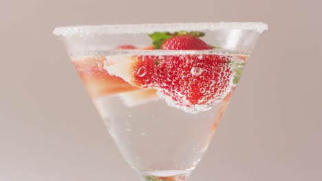 close up of drink with sugar and strawberries on white background