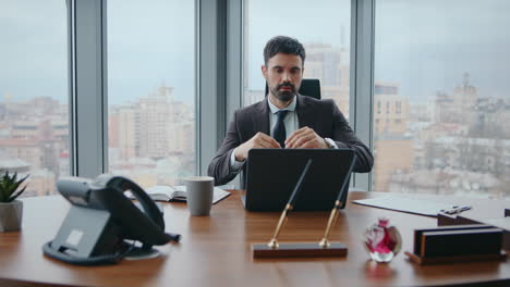 jefe reflexivo sentado en el escritorio de la oficina mirando la pantalla de la computadora portátil de cerca. hombre preocupado