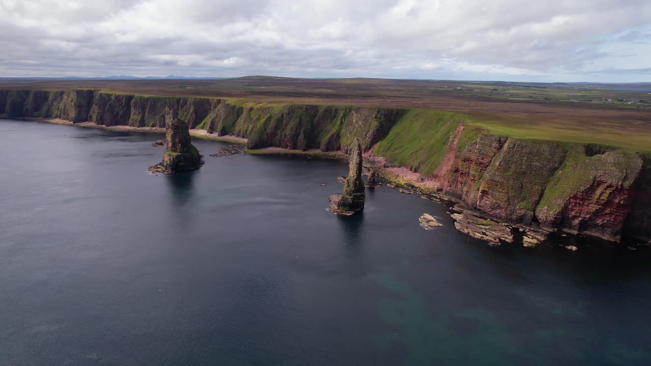 A serene aerial view of Scotland's dramatic sea cliffs and unique rock formations