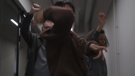 happy people dancing in an office corridor