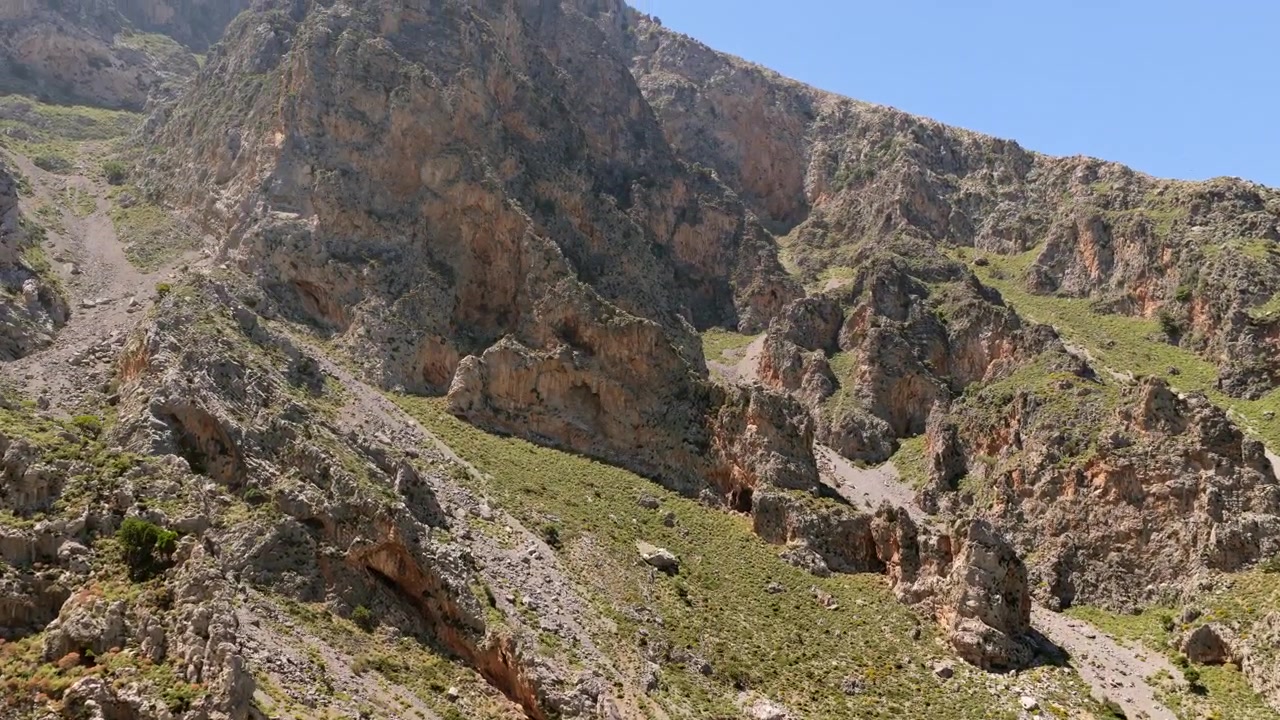 Veduta aerea con drone di una parete montuosa rocciosa e frastagliata con scogliere a picco e pinnacoli sopra una gola impervia, Gola di Kourtaliotiko, Grecia