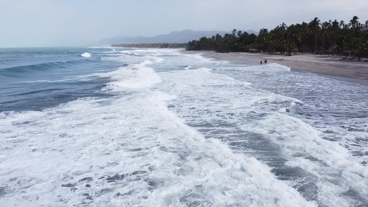 Visitantes em praia selvagem do Caribe colombiano desfrutam de ondas brancas sem fim