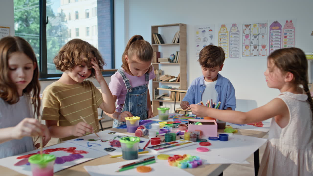 Pupils creating colorful art at collaborative workshop with vibrant materials