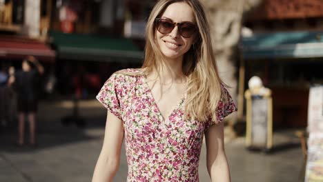 Rear-view-of-young-blondy-woman-in-dress-walks-by-old-european-town