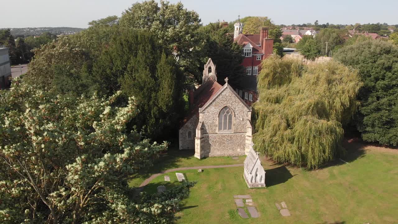 Left-to-right parallax drone shot revealing St Nicholas Church in lush surroundings.