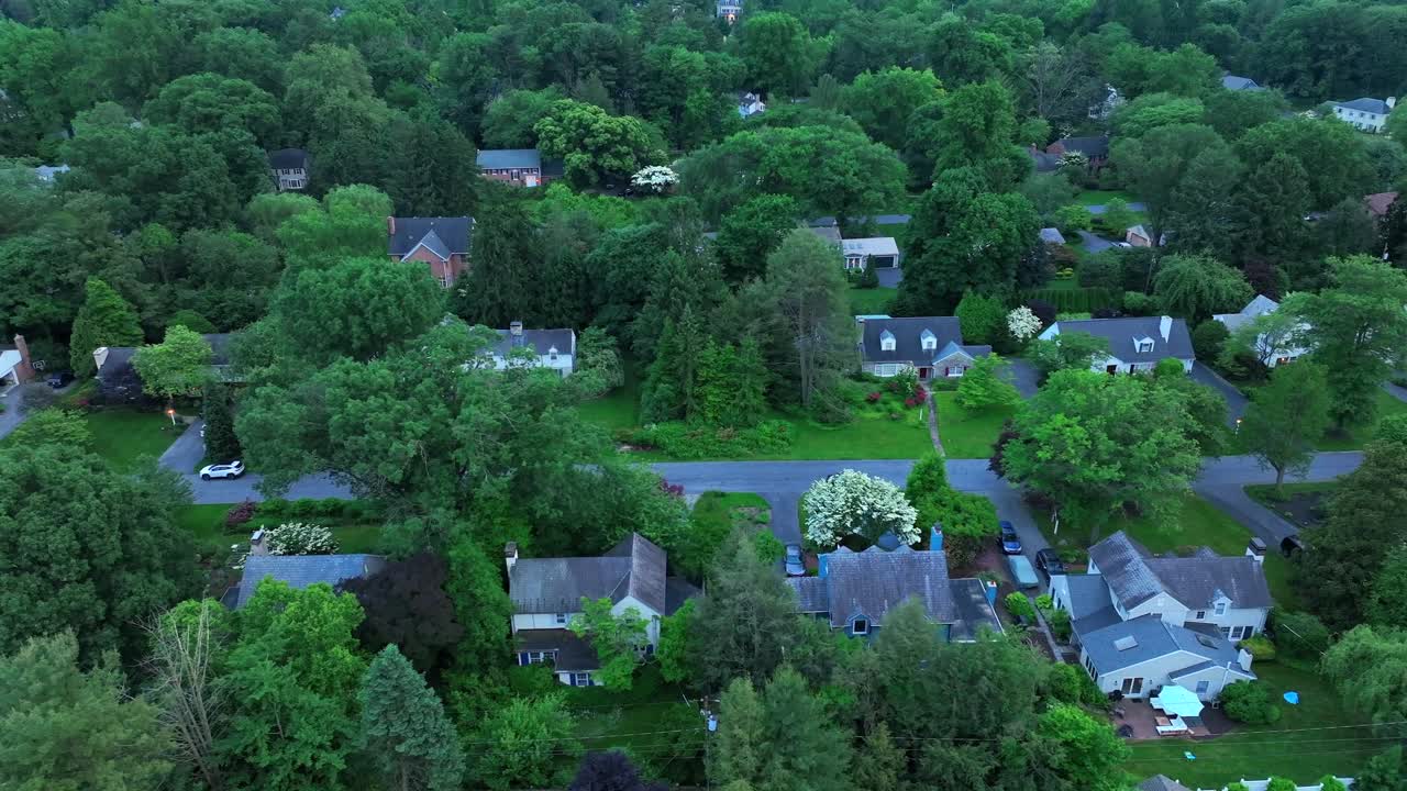 Houses and Villas in green neighborhood with trees and green leaves at dusk