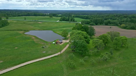 the gorgeous drone shot brings out the true beauty of this lush farmland landscape with a pond, which is really a sight for sore eyes