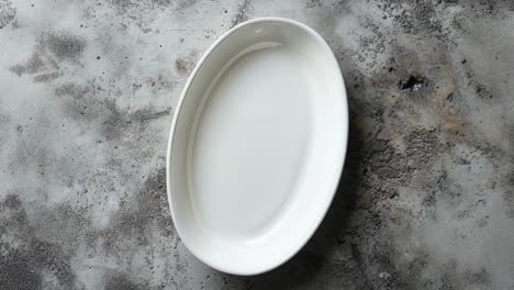 plato de cerámica ovalado blanco sobre un fondo gris