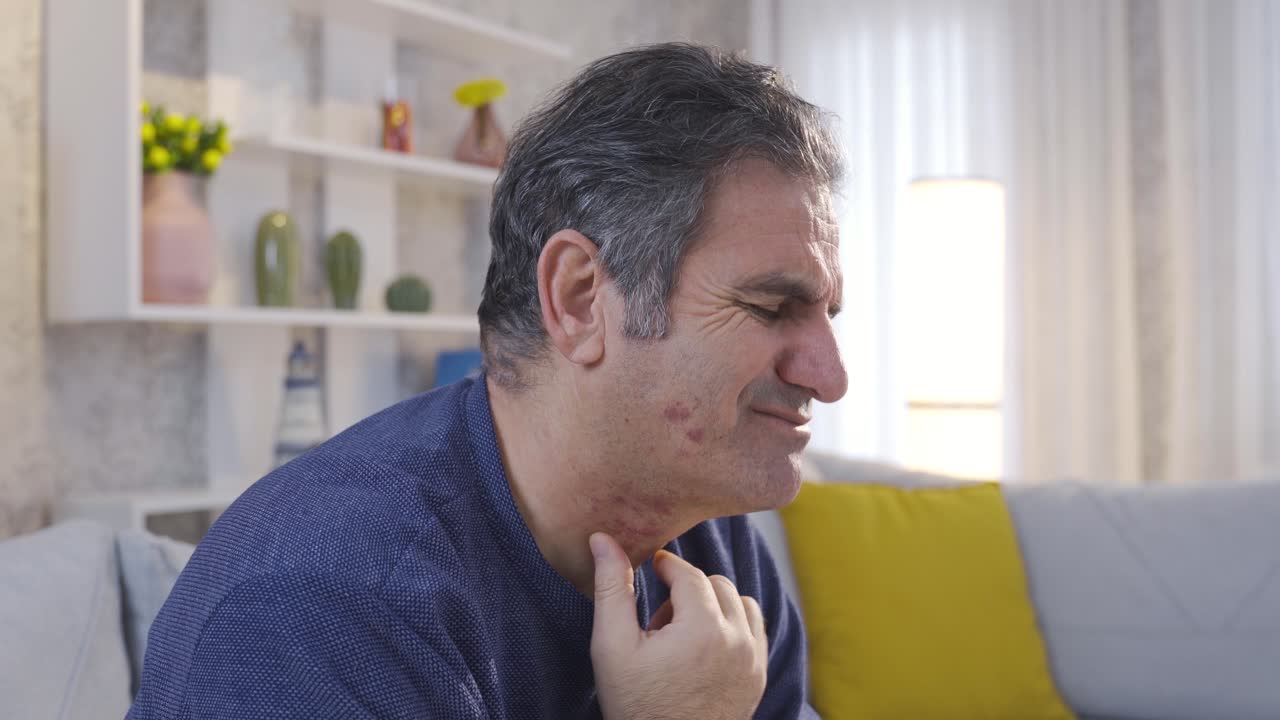 el enfermo con dolor de garganta toca la garganta con las manos y siente dolor.