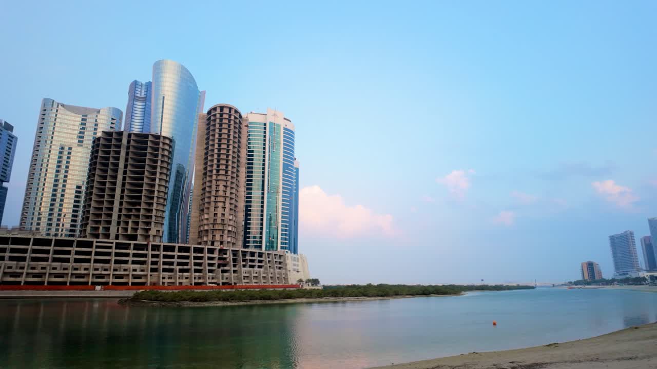 Al Reem Island’s emerging skyline at sunrise. This is a new, man-made island on land reclaimed artificially from the Arabian Gulf. Panoramic view of the city construction, mangrove forest, and sea