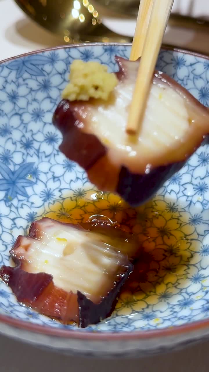 palillos para comer recogiendo calamares de un cuenco