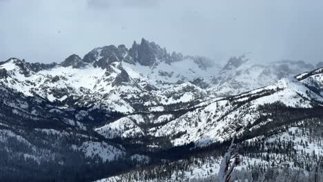 the hemlocks mammoth mountain ski resort california winter spring blizzard deep powder snow misty fog foggy minarets jagged peaks vista view chairlift gray clouds mystical sun pan left motion