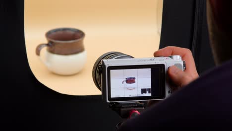 Man-taking-photos-of-coffee-cup-in-a-light-box