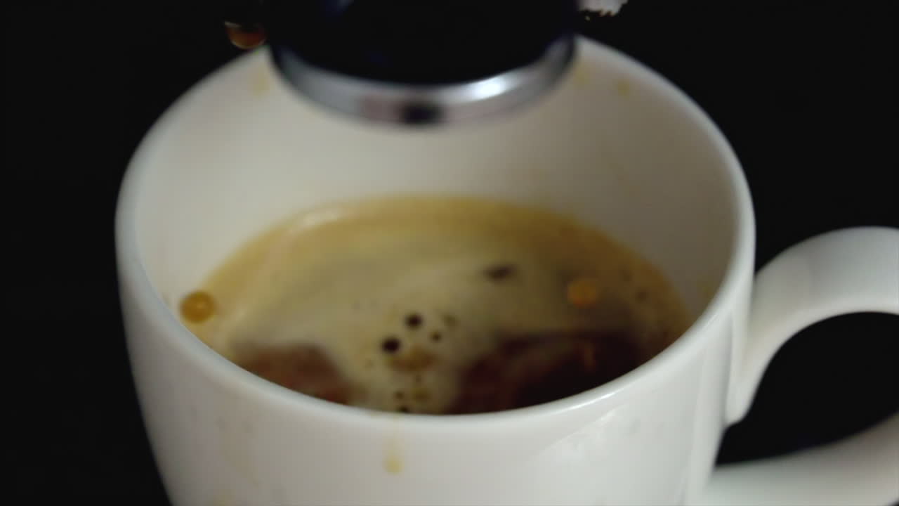 Close up of coffee pouring from a machine in a espresso cup