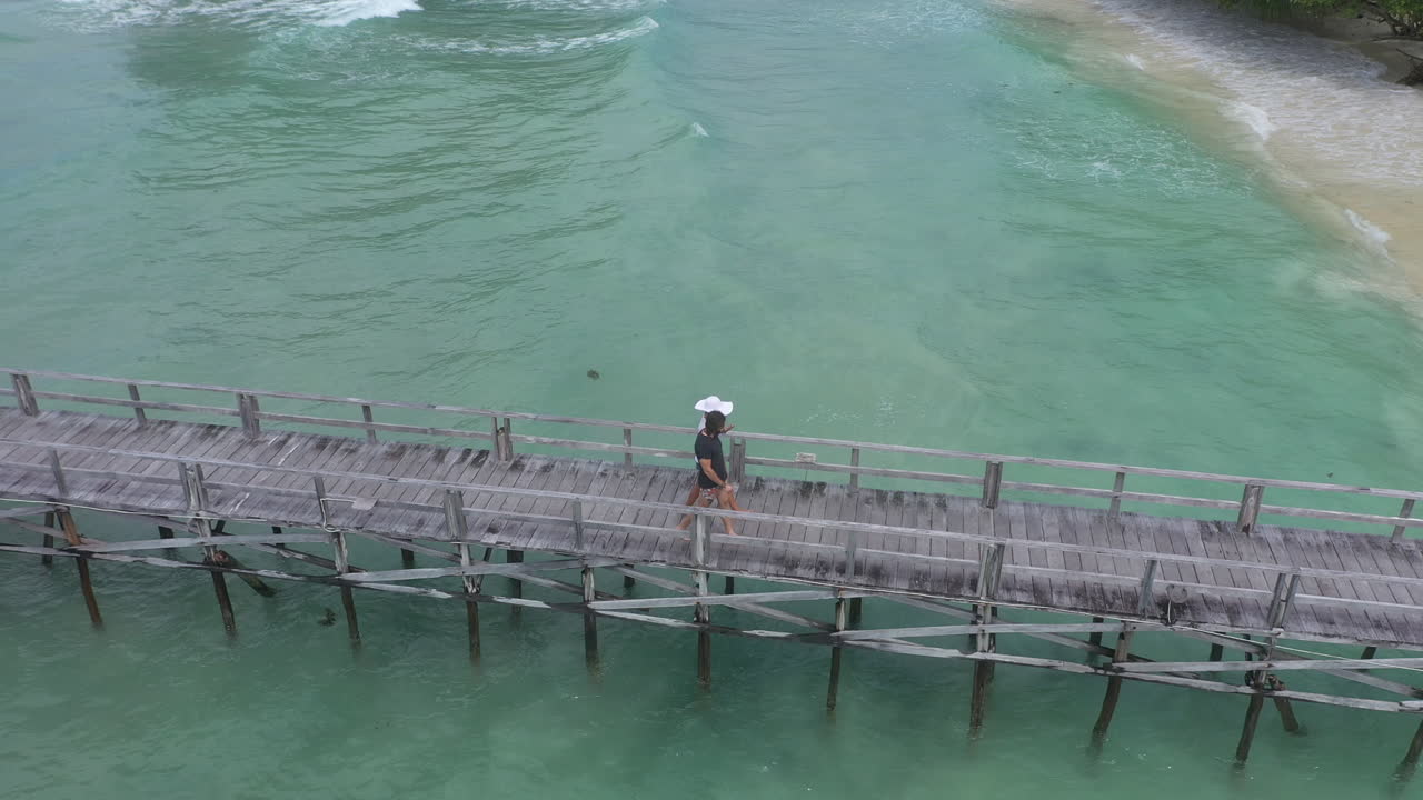 Couple Walking on Wooden Pier over Turquoise Water