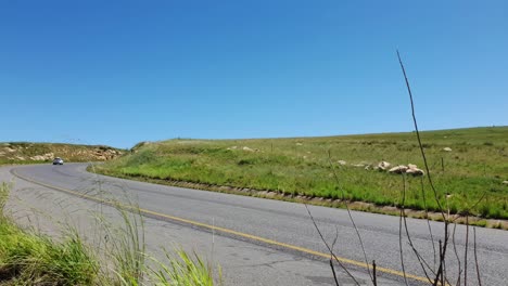 R711-road-outside-Clarens-town-in-Free-state-province-South-Africa-with-cars-and-motorbike-traffic-traveling-past-on-vacation-in-Moluti-Mountains