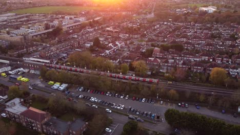 toma aérea sobre el norte de londres mientras dos trenes se cruzan en el metro subterráneo.