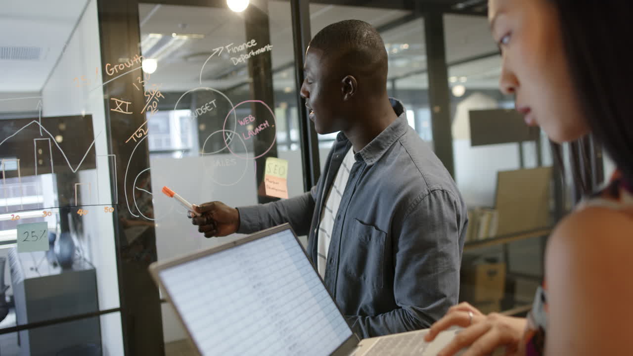 African american businessman discussing with female colleague in office, slow motion, copy space