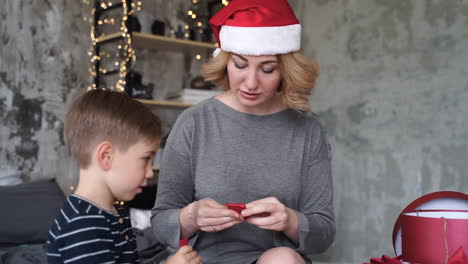 Mother-And-Son-Prepare-Ribbons-Of-Christmas-Gifts