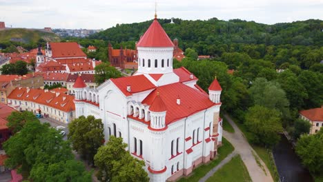 Church with red rooftop and skyline of Vilnius, aerial drone view