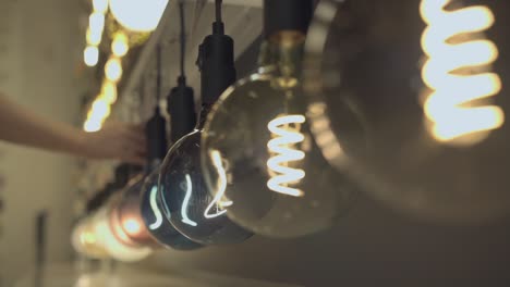 un hombre enciende una fila de bombillas una por una, en una tienda de luces