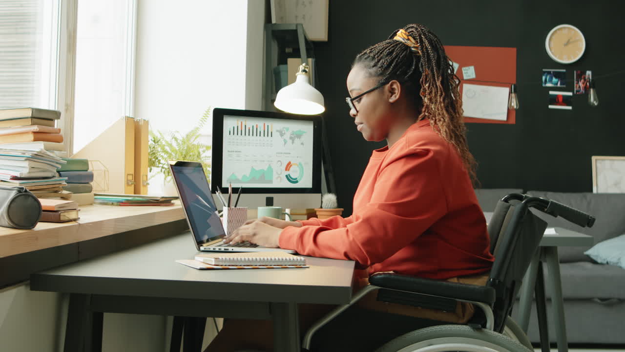 African American Woman in Wheelchair Working from Home
