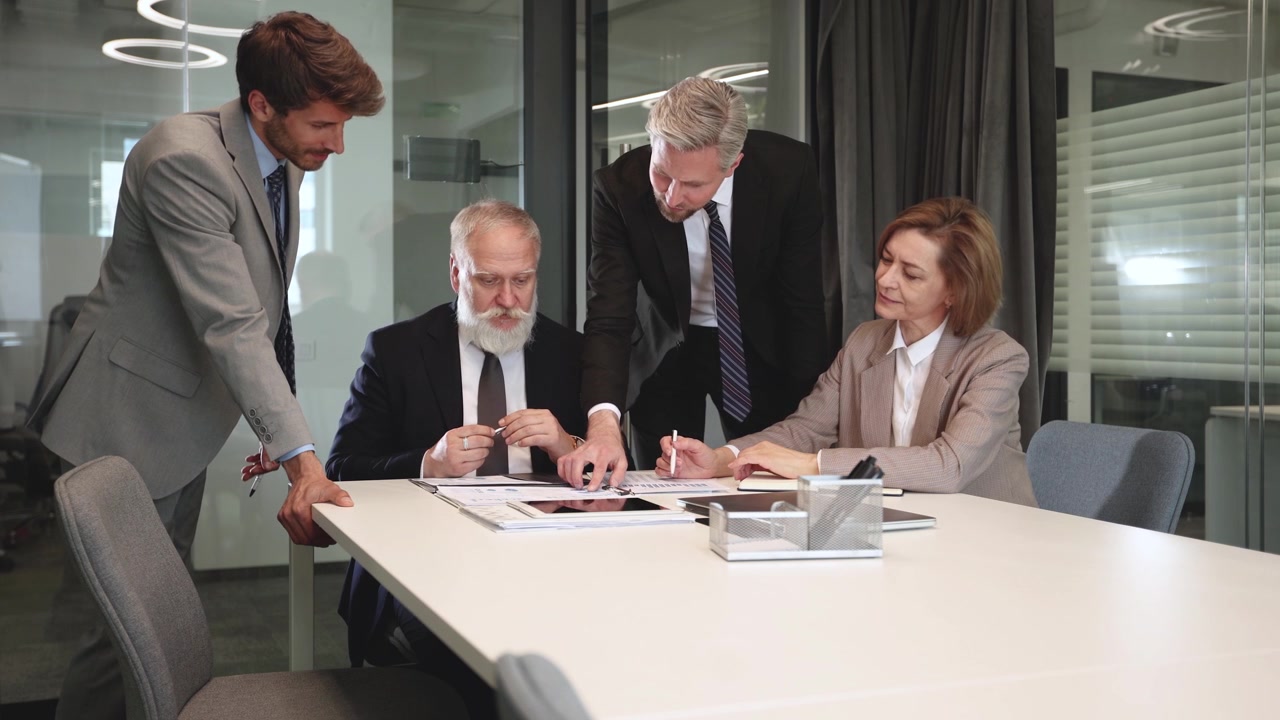 Business Professionals Discussing Documents and Tablet in Office Meeting